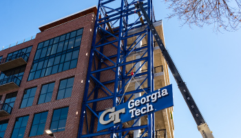 Construction crane lifting Georgia Tech logo