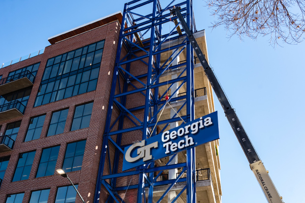 Construction crane lifting Georgia Tech logo