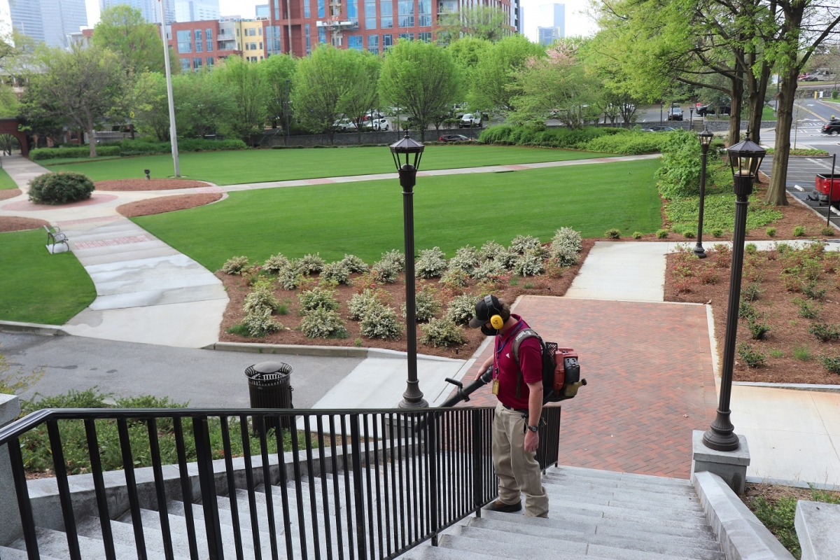 steps with landscape personnel blowing leaves with landscape in background