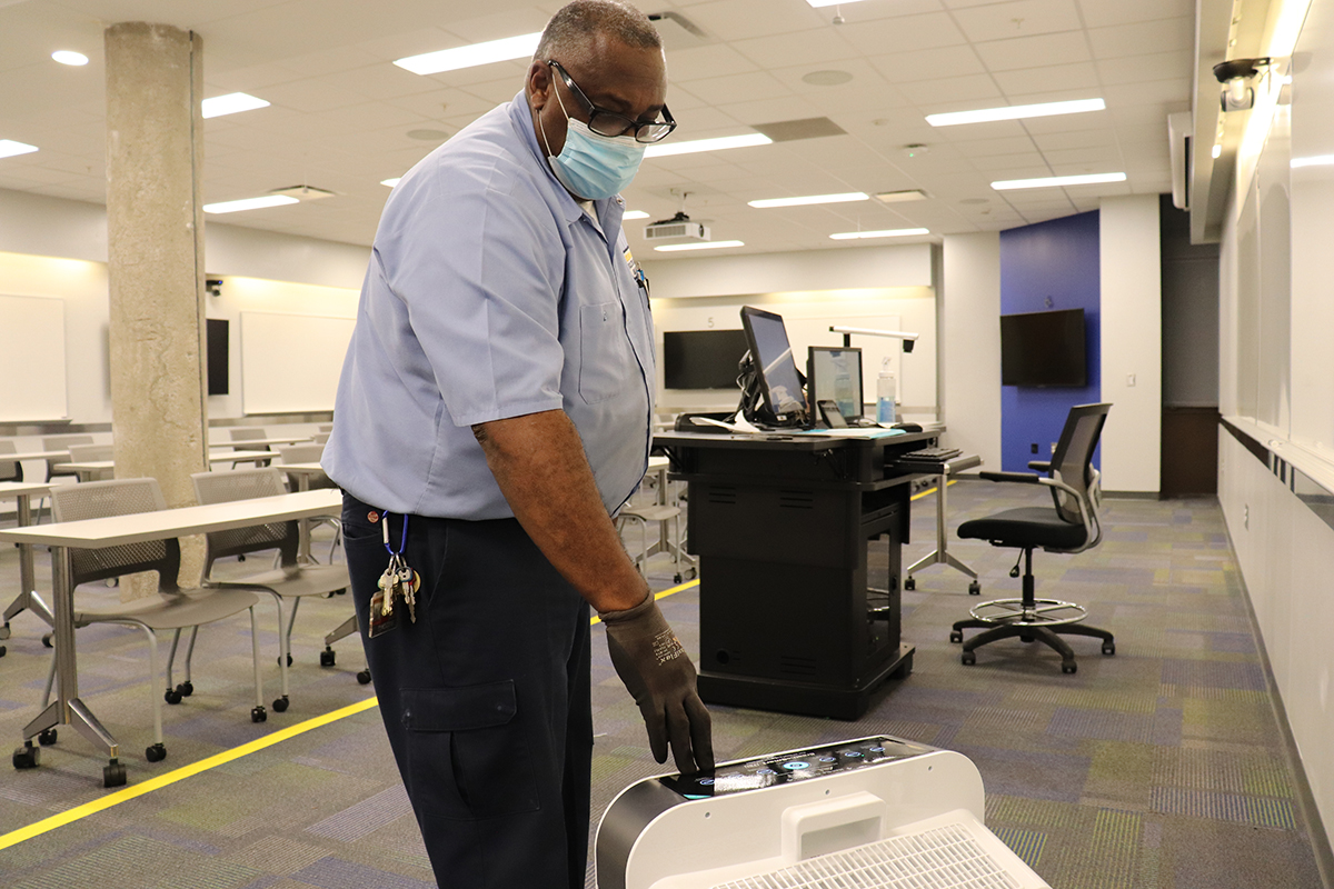 Albert Williams (A/C Mechanic II) tests an air scrubber in a classroom on Tuesday, Aug. 17. (Photo by Jeff Wiley)