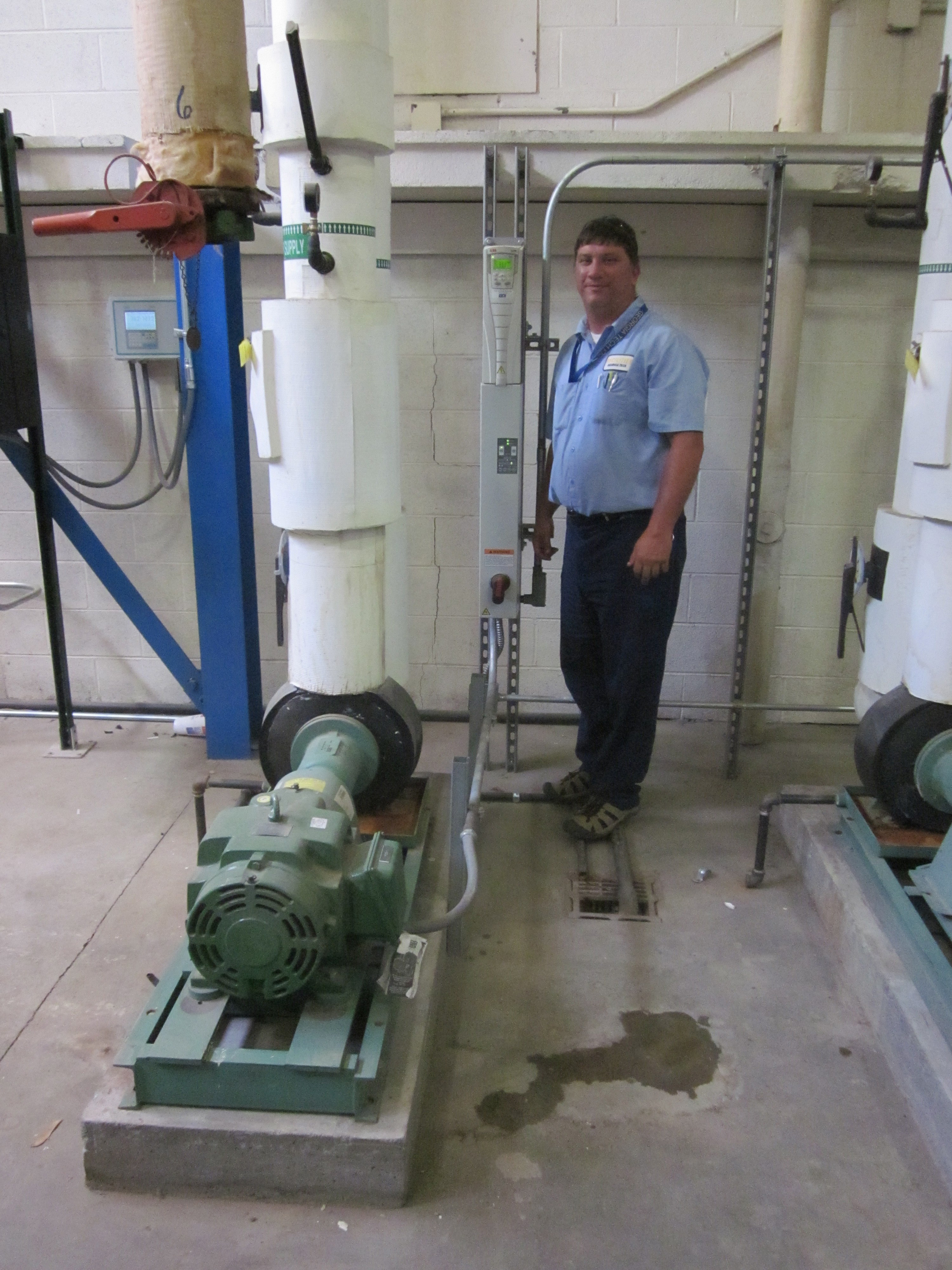 John McElreath, a Facilities electrician, with a variable frequency drive adjacent to the motor it controls.