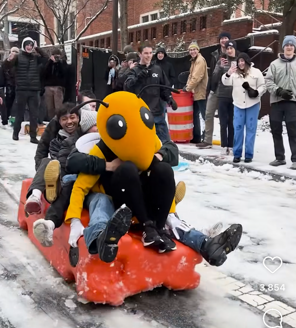 Buzz and students sledding on a construction barrier.